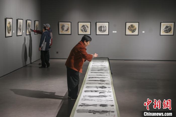 中国侨网12月27日，江西南昌，“创新与发展”——迎新春 宋铁鳌新钢笔画作品展在江西师范大学瑶湖校区美术馆开展，由江西知名艺术家、江西省钢笔书画院院长宋铁鳌创作的147幅单幅作品和4幅长卷作品被集中展出，其中包括《清明上河图》《赣鄱山水图》等著名钢笔画作品。图为观众在观看展览。中新社记者 刘力鑫 摄